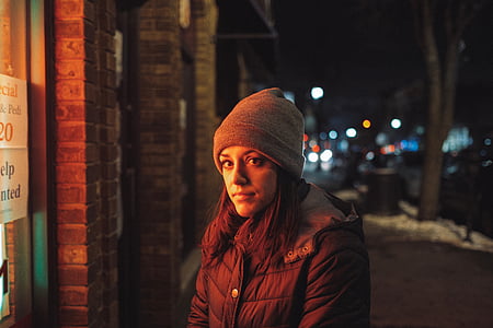 woman standing outside store during nighttime thumbnail