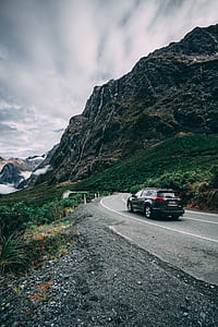 black SUV on road towards mountain thumbnail