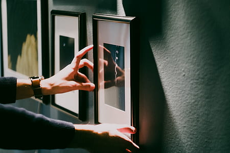 person touching framed wall decoration thumbnail