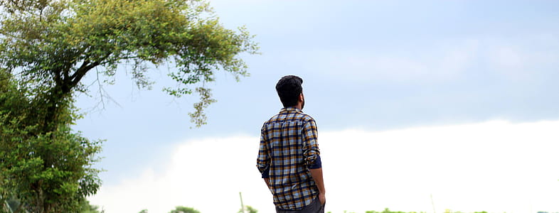 man standing near tree thumbnail