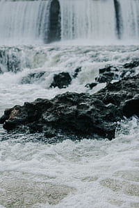 long exposure photo of body of water and rock formations thumbnail