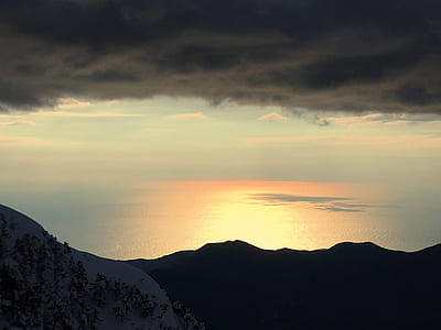 arcus clouds over mountain silhouette by the sea thumbnail