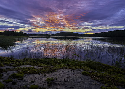 silhouette of mountain near body of water thumbnail