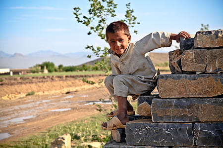 boy in gray shirt on pile of bricks thumbnail