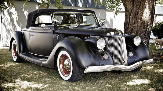 vintage black car parked near white wall thumbnail
