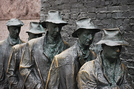 five statues beside stone wall thumbnail
