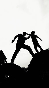 silhouette photo of man and boy standing near house during daytime thumbnail