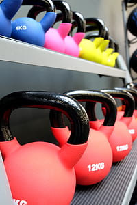 shallow focus photography of kettlebells on top of rack thumbnail