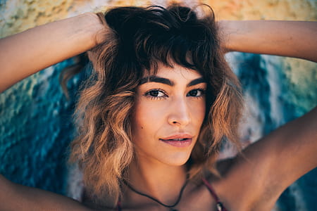 smiling woman holding blonde hair at daytime thumbnail
