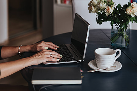 Woman using a laptop by a round breakfast table thumbnail