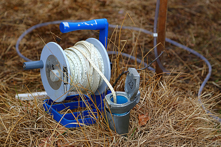blue and gray reel with white rope that that leads to gray pipe thumbnail