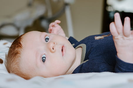 selective focus photography of boy on white pad thumbnail