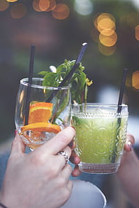 selective focus photography of two person holding clear drinking glasses with bokeh light background thumbnail