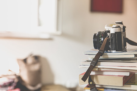 photo of black and silver disposable camera on top of books thumbnail
