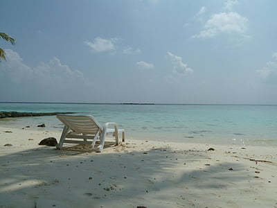 white metal lounger placed on white beach sand at daytime thumbnail