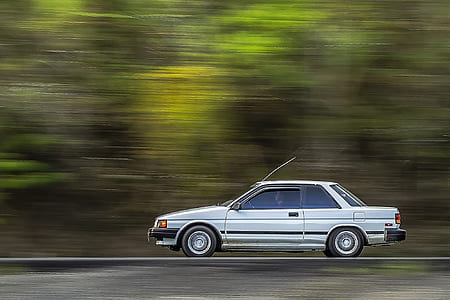 time lapse photo of white coupe running on road thumbnail