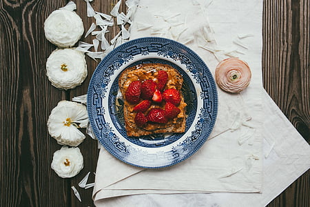 slices of strawberries on white and blue ceramic palte thumbnail