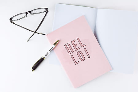 pen, eyeglasses, and pink paper on white desk thumbnail