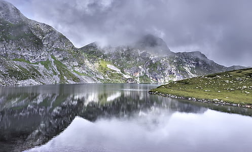 calm body of water between mountains during daytime thumbnail