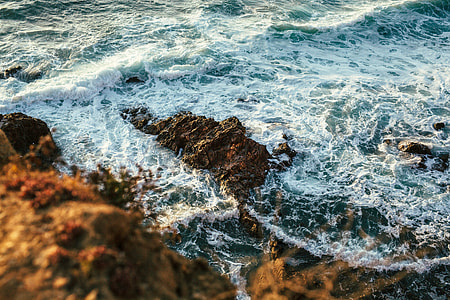 rocky seashore with sea wave at daytime thumbnail