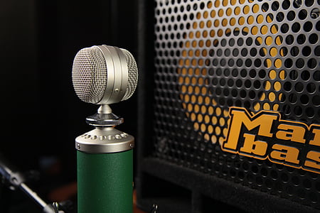 gray and green microphone in front of speaker thumbnail