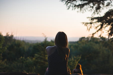 Woman Wearing Black Sleeveless Top in Front of Green Leaf Trees thumbnail