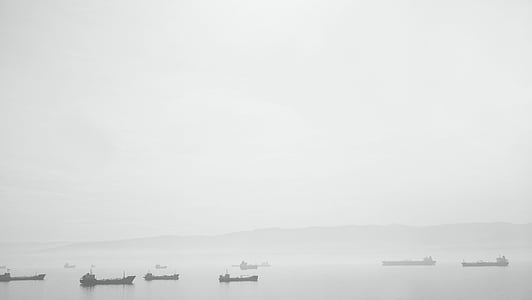 silhouette of boats on body of water thumbnail