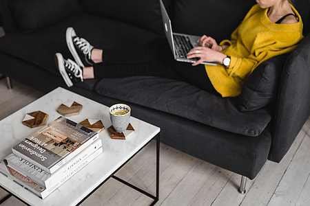 Young woman sitting on the sofa and working on her laptop thumbnail