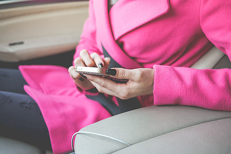 Nicely Dressed Woman Using Her Phone in a Car thumbnail