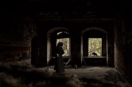 person wearing gray robe standing near window thumbnail