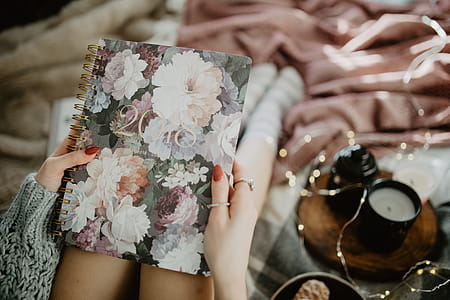 Writing in a notebook lying in bed, with coffee, candles, and gingerbreads thumbnail