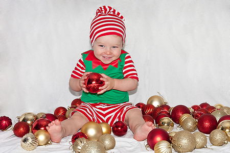 baby playing gold and red baubles thumbnail