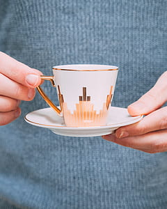 person holding teacup with saucer thumbnail