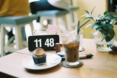 clear drinking glass with brown liquid on top of brown wooden table thumbnail
