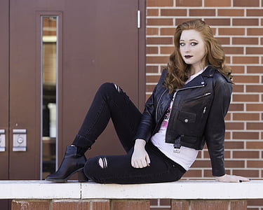 woman in black leather jacket sitting on railing thumbnail