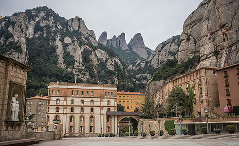 concrete buildings in a distance of rocky mountains at daytime thumbnail