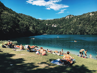 woman sitting on blue bench hair beside lake thumbnail
