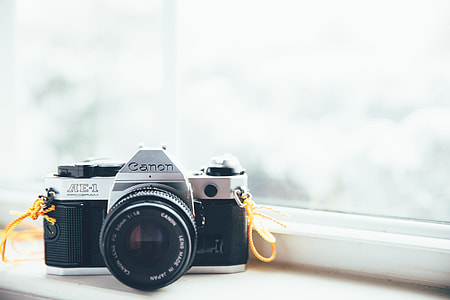 gray and black Canon DSLR camera in front of window thumbnail