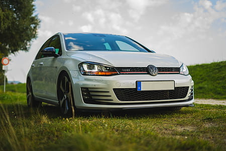 white Volkswagen sedan on green grass thumbnail