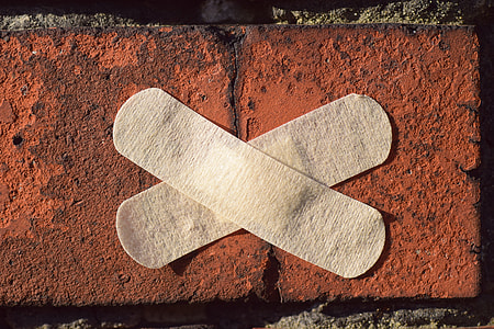 two gray band aids on brown concrete brick thumbnail