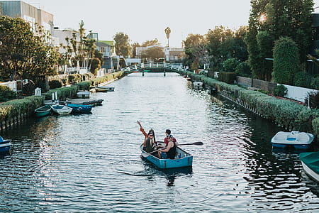 people rowing wooden boat on the river thumbnail