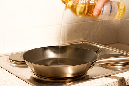 person pouring oil in frying pan thumbnail
