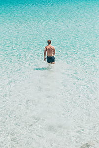 man in black board shorts in body of water thumbnail