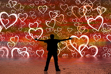 silhouette of man spreading his hands with heart-printed background thumbnail