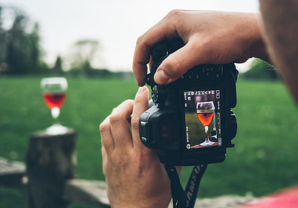 person taking photo of wine glass thumbnail