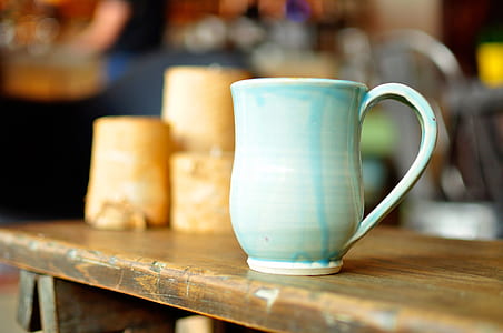 white and blue ceramic mug on brown wooden surface thumbnail