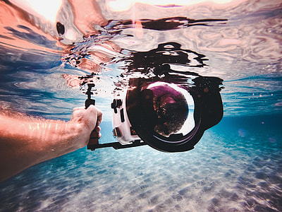 underwater photography of person holding white camera thumbnail