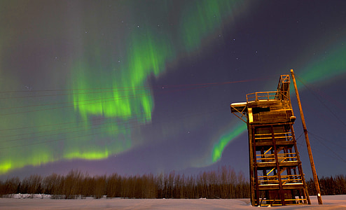 low-angle view photo of tower under aurora boriales thumbnail