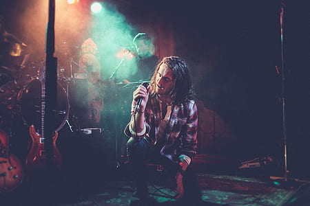 vocalist band singing while bending his knee on floor thumbnail