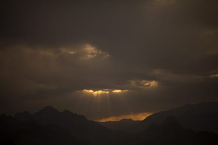 silhouette photography of mountains and clouds thumbnail